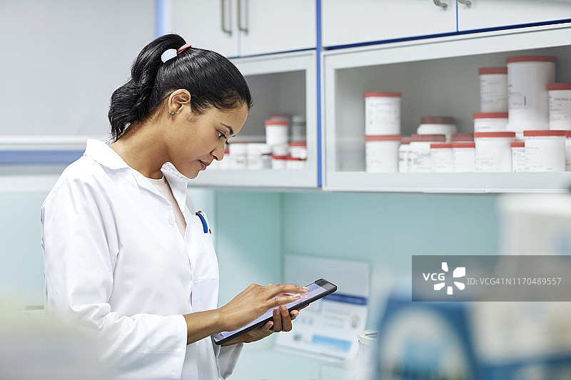 年轻药剂师在医院使用平板电脑图片素材