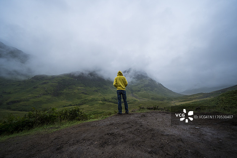 一名男性游客在雾天探索三姐妹山脉图片素材