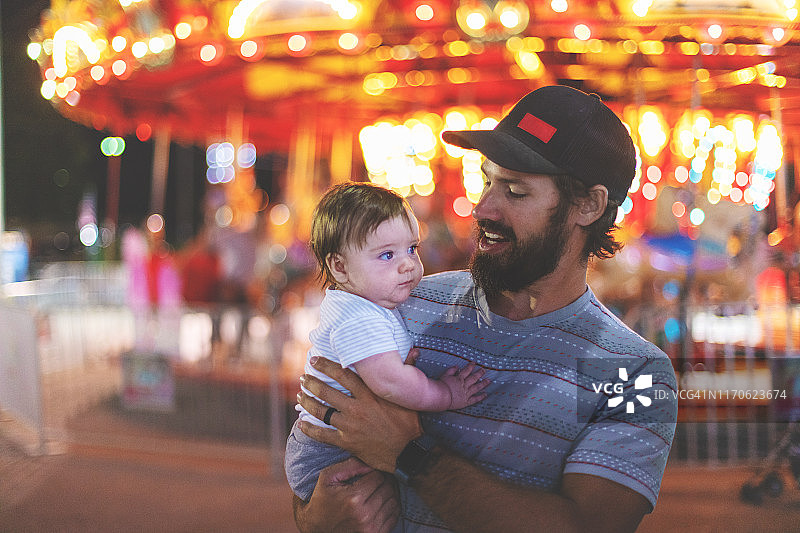 年轻的千禧一代父亲在斯普林菲尔德帝国州博览会上与他年幼的儿子共度时光图片素材