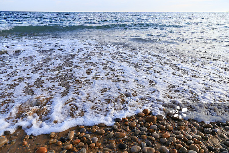 岸边有水的鹅卵石滩图片素材