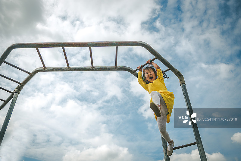 在单杠上玩耍的年轻女孩图片素材