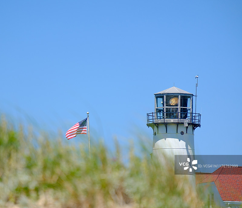 查塔姆灯塔在马萨诸塞州科德角海滩的沙丘后探出头图片素材