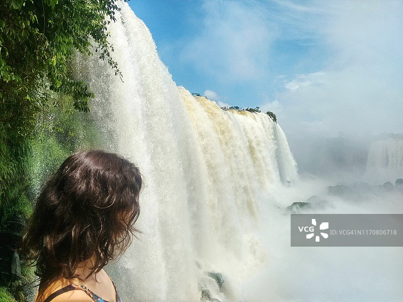女游客在巴西和阿根廷的伊瓜苏瀑布图片素材