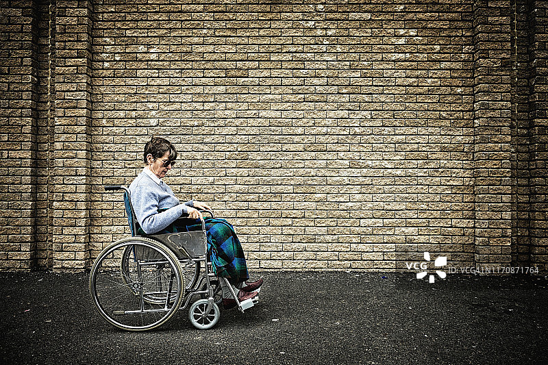 坐在轮椅上，面容沮丧的老年妇女图片素材