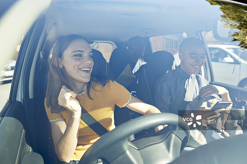 快乐的年轻女子在车里和朋友们跳舞图片素材
