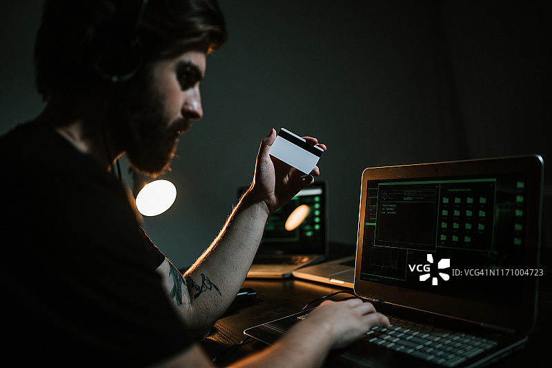 黑客使用笔记本电脑窃取信用卡信息图片素材