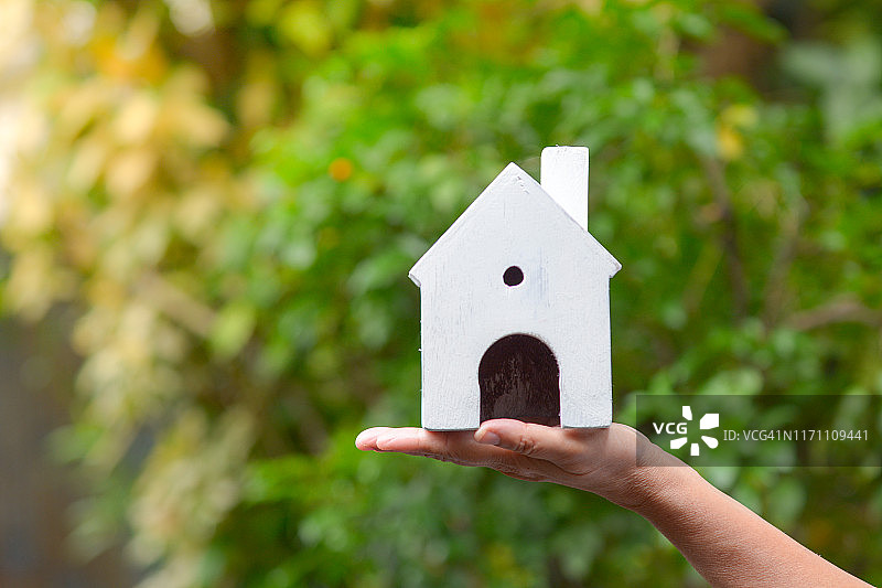 手中的白色房屋模型，房地产概念图片素材