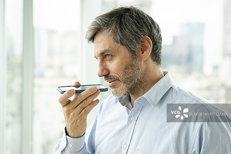 在办公室使用扬声器打电话的商人图片素材