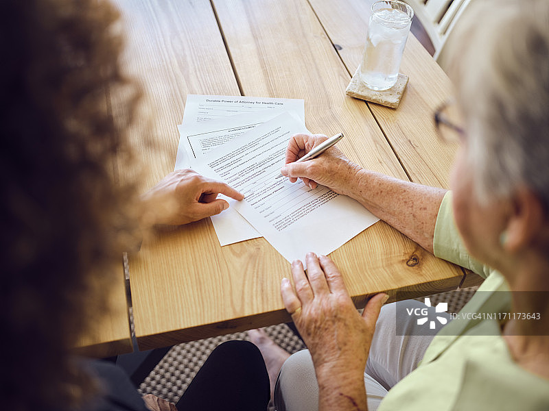 年长的女人在家中签署文件图片素材