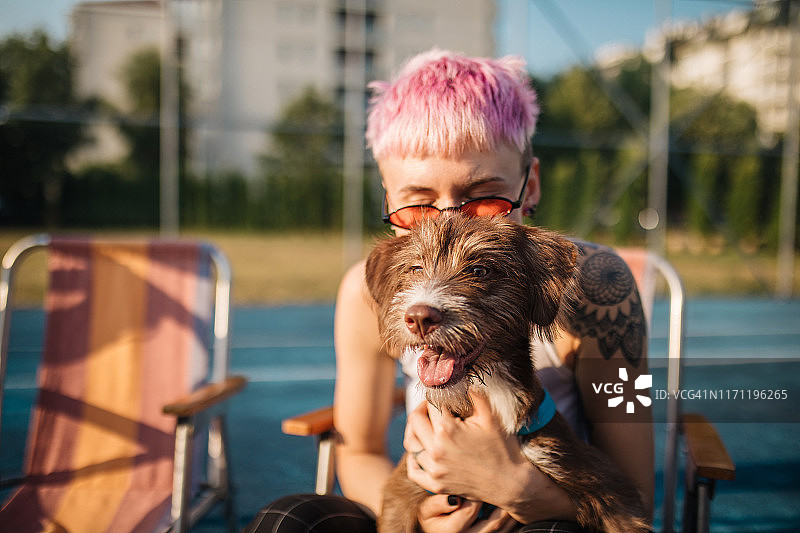 粉色头发的另类女孩和她的狗图片素材