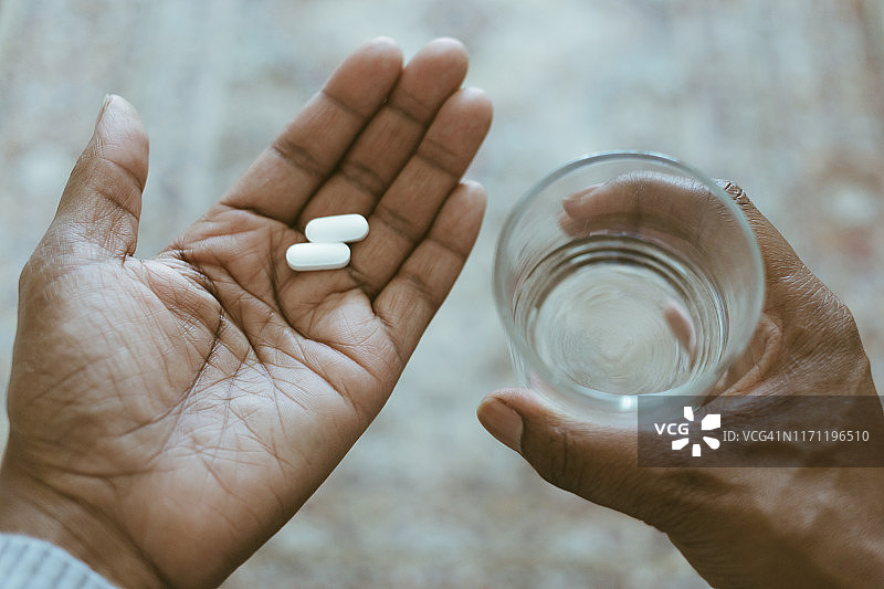手拿药丸和水的特写镜头图片素材