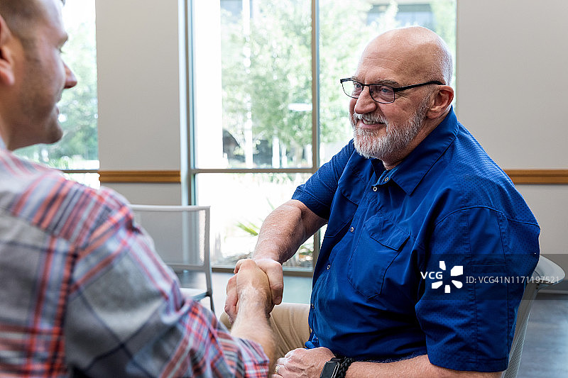 中年父亲与中年儿子握手图片素材