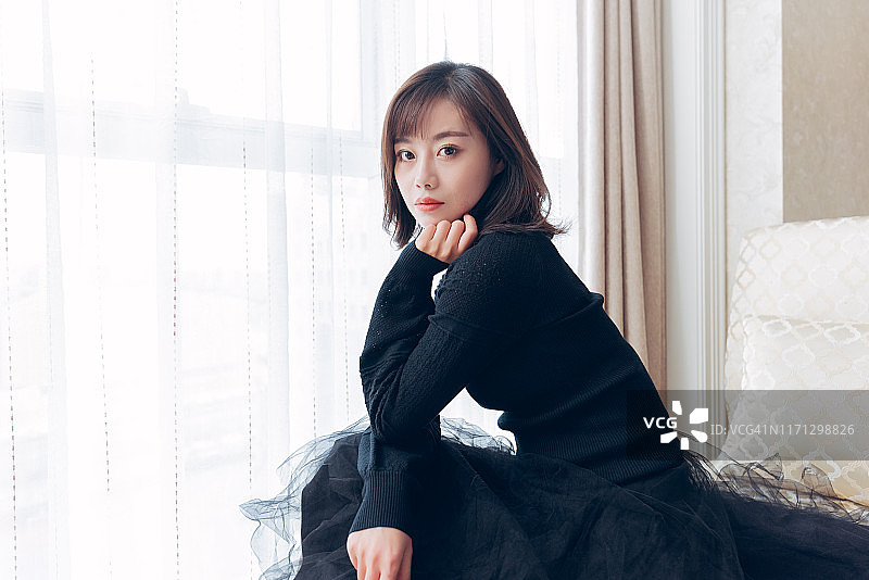 美丽的亚洲女性坐在窗前图片素材