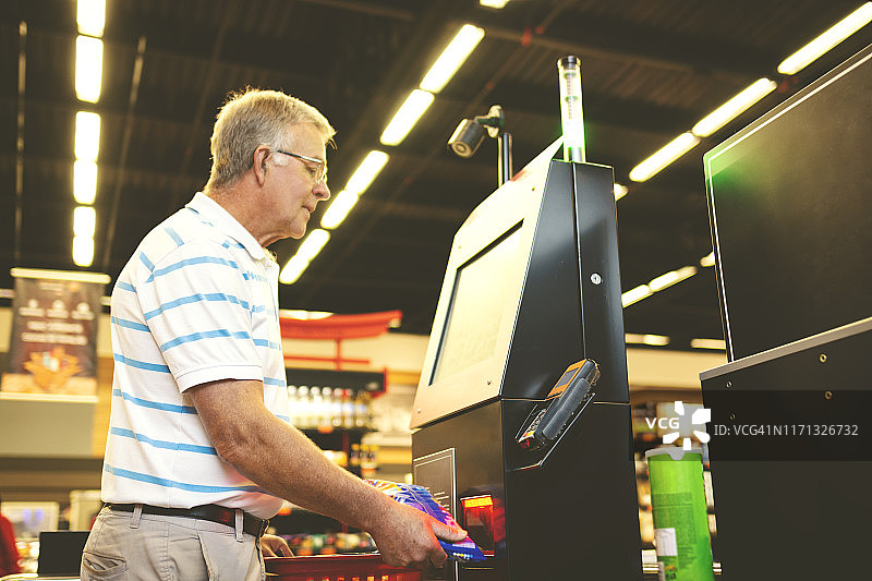 男子在超市自助服务区付款图片素材
