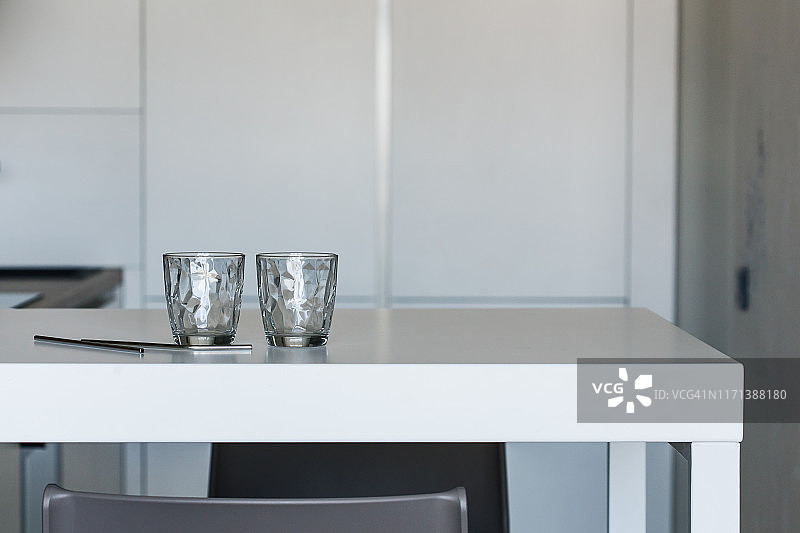 可重复使用的金属吸管和厨房台面上的空玻璃杯图片素材