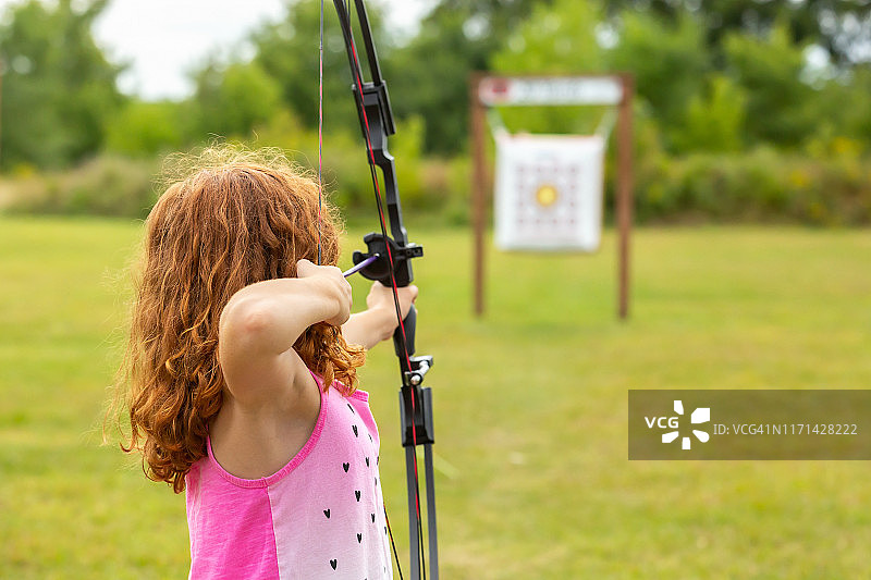 在户外射击场练习射箭的女孩图片素材