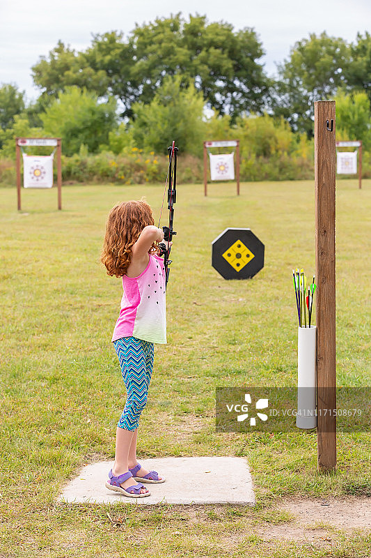 在户外射击场练习射箭的女孩图片素材