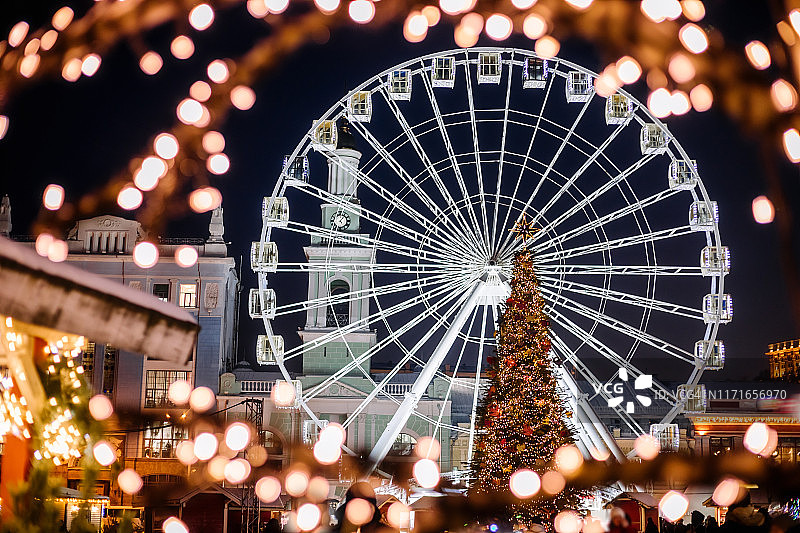 夜间城市的摩天轮和圣诞树图片素材