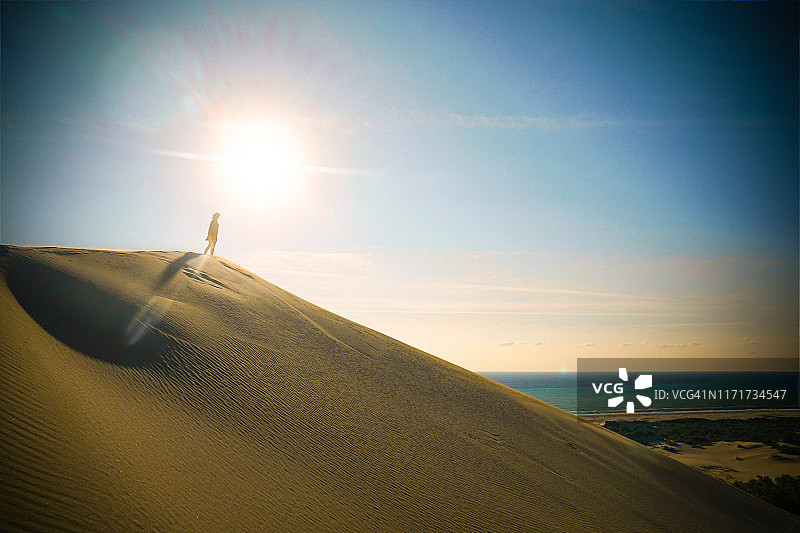在沙丘中行走的年轻漂亮女人图片素材