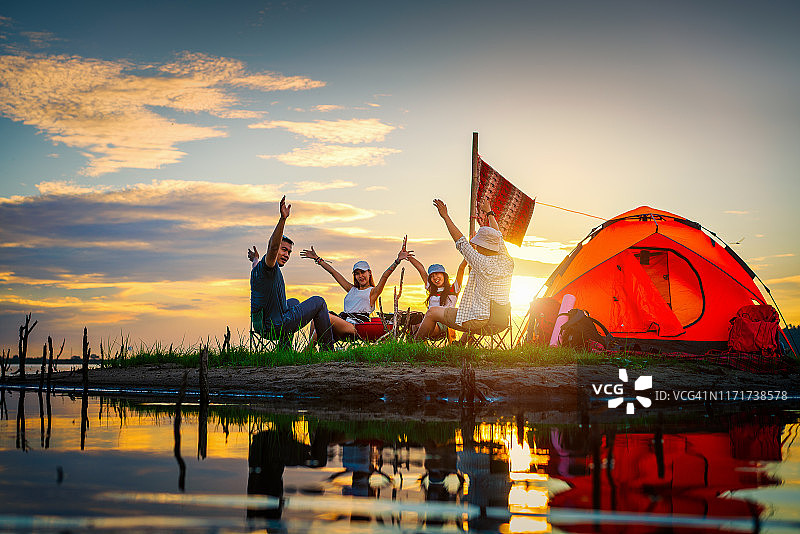 快乐的徒步旅行者在帐篷附近露营图片素材