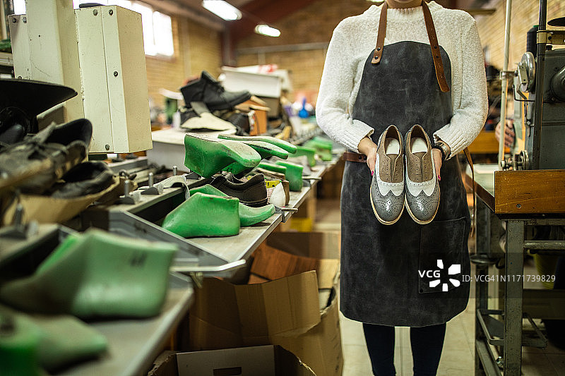 女子手持牛津鞋模型（仅见背影）图片素材