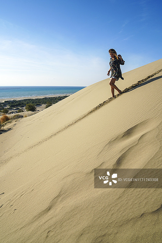 在沙丘中行走的年轻漂亮女人图片素材