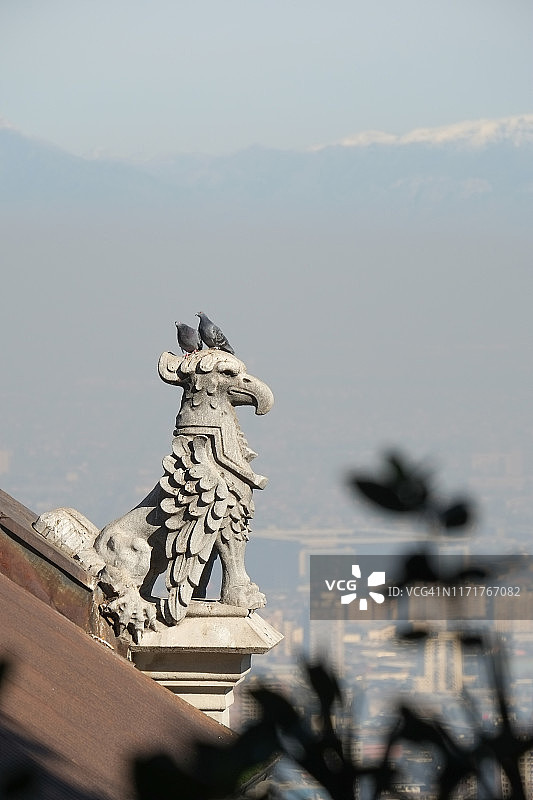 石像鬼位于圣地亚哥上方，俯瞰城市和山脉图片素材