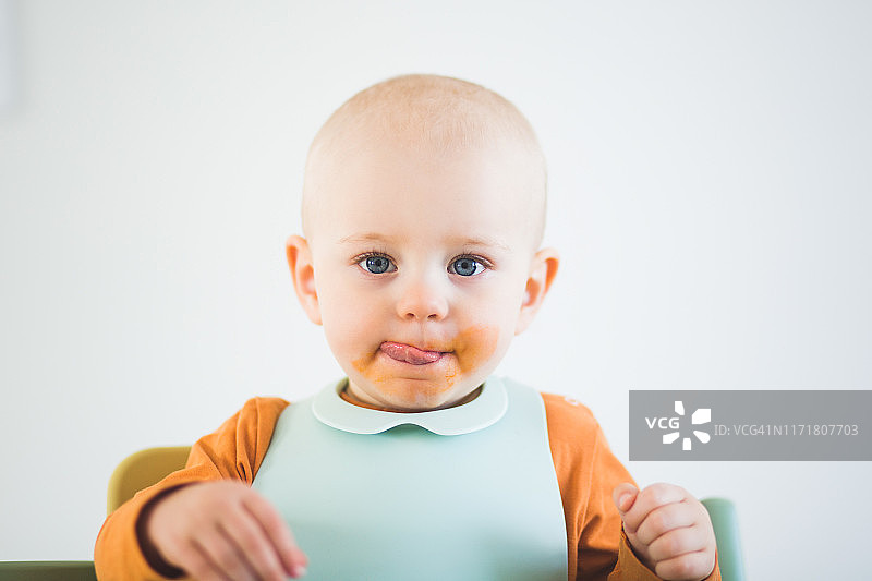 女婴在家中舔脏兮兮的嘴巴肖像图片素材