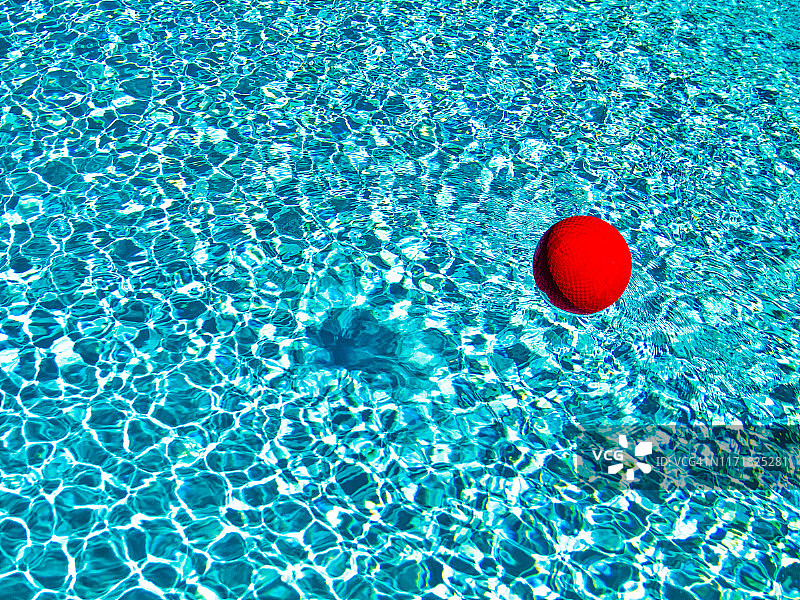 蓝色泳池中漂浮的红色球图片素材