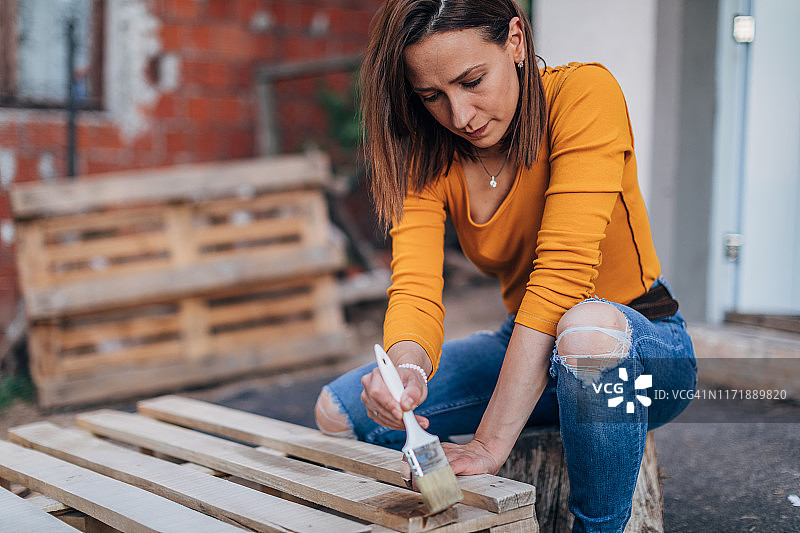 女人用画笔涂刷木板图片素材