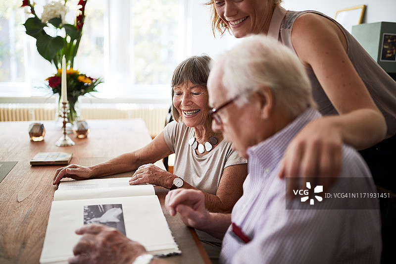幸福家庭在家看旧相册图片素材