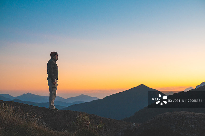 日出时分，男子在山中行走图片素材