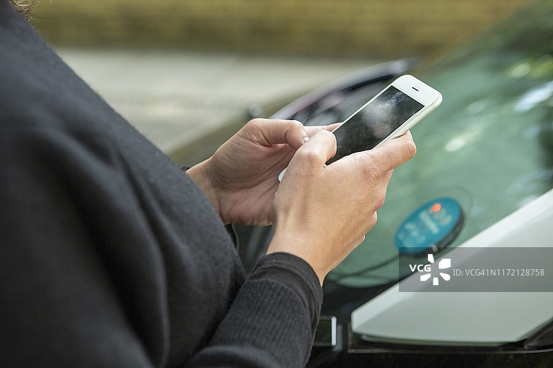近距离拍摄使用智能手机访问汽车共享服务的女人图片素材