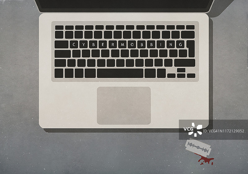 网络暴力：带血刀片旁的笔记本键盘文字图片素材