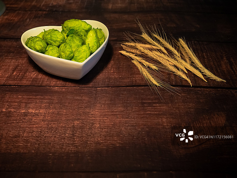 自制精酿啤酒：心形瓷碗中的啤酒花和麦穗图片素材