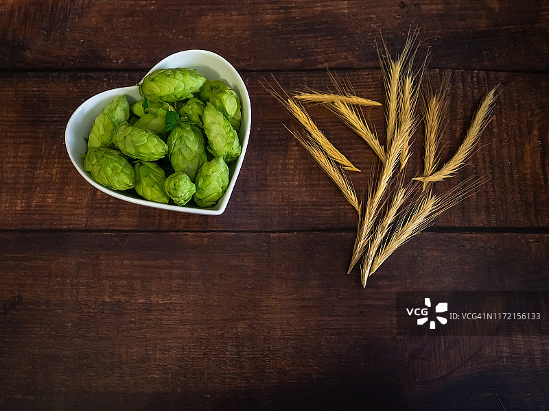 自制精酿啤酒：心形瓷碗中的啤酒花和麦穗图片素材