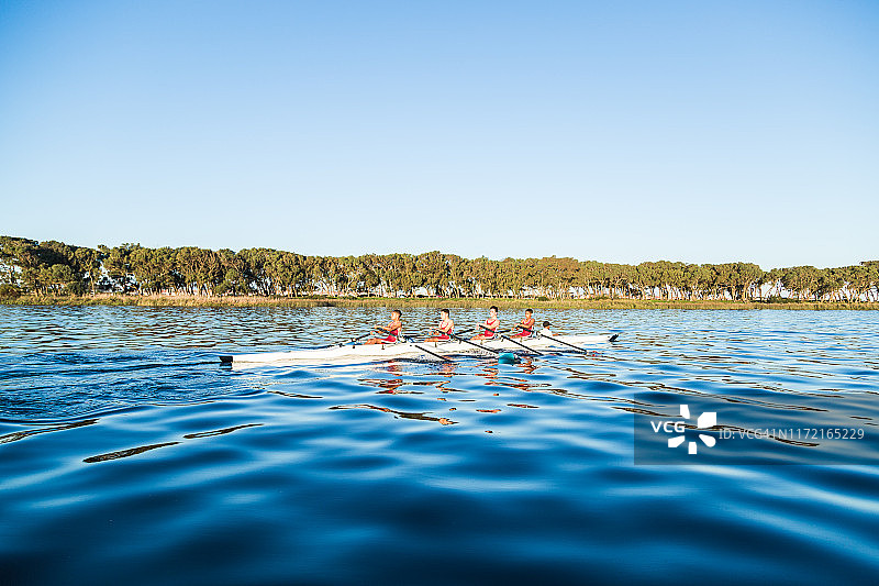 混血赛艇队在黎明时在湖上训练图片素材
