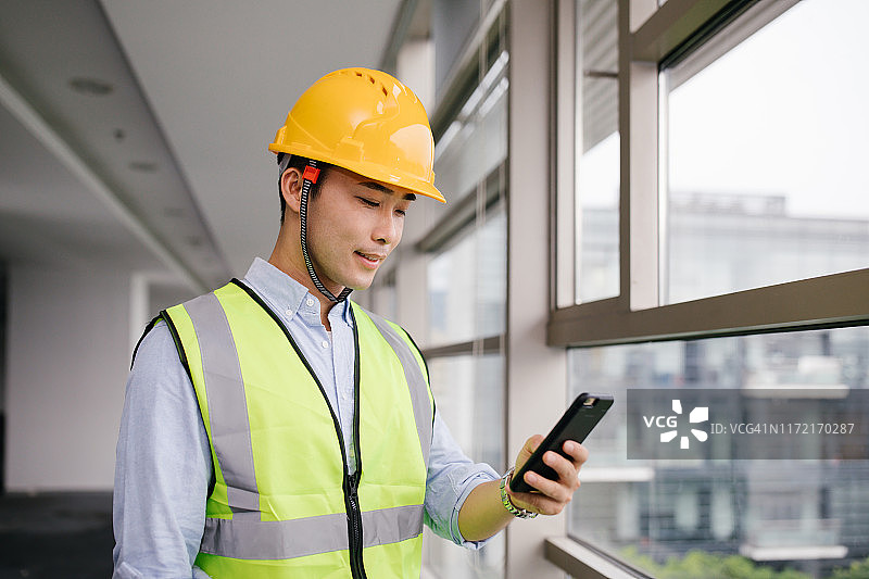 在建筑工地工作的亚洲商人，工程与商务概念图片素材