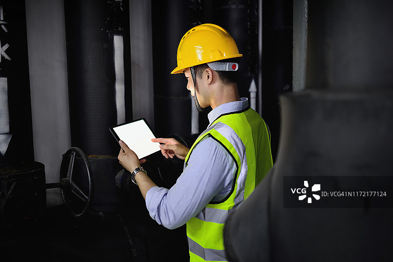 在黑色管道背景工作的工程师图片素材