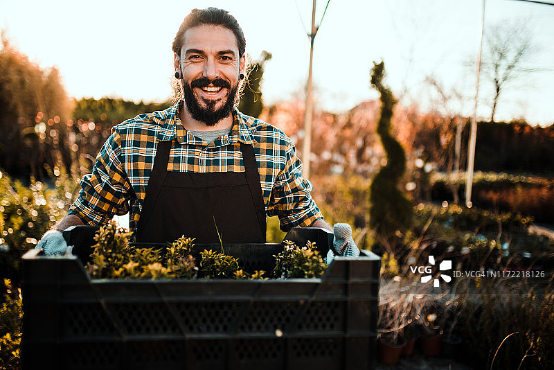 在花园里搬运植物的男人图片素材