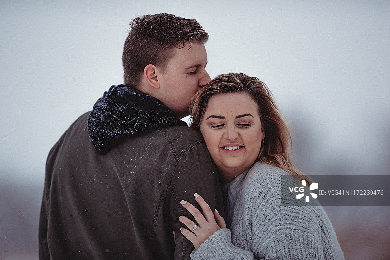 情侣在爱荷华州冬季风暴雪中拍摄订婚照图片素材