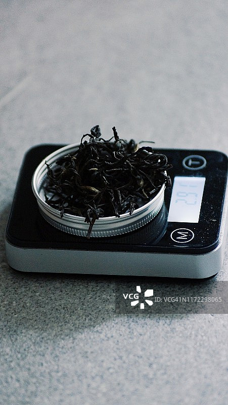 在厨房秤上称量干燥的红茶茶叶图片素材
