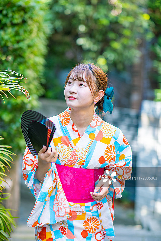 身穿浴衣走在住宅区的年轻女人图片素材