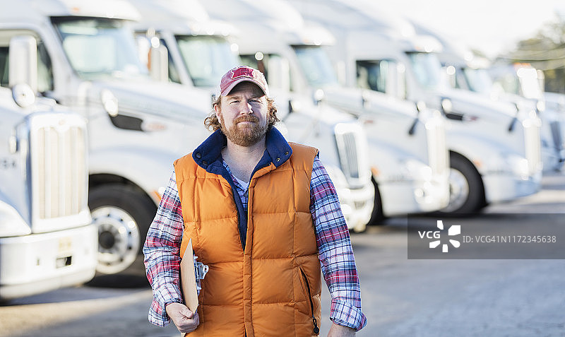 男人站在半挂卡车车队前图片素材