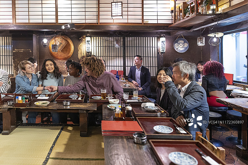 人们在东京的餐厅享用晚餐和饮品图片素材