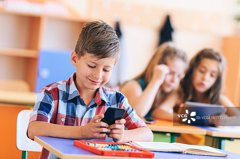 在教室里使用手机的男学生图片素材