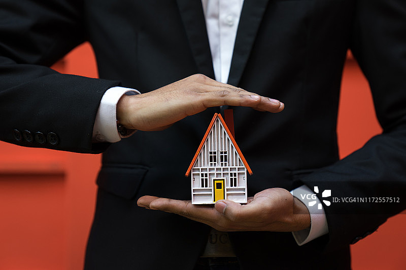 房屋保险概念，商人手中的美丽房子图片素材