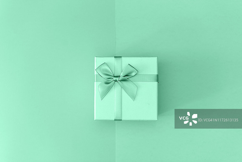 黑色背景上的薄荷绿丝带黑色包装纸礼盒顶视图图片素材
