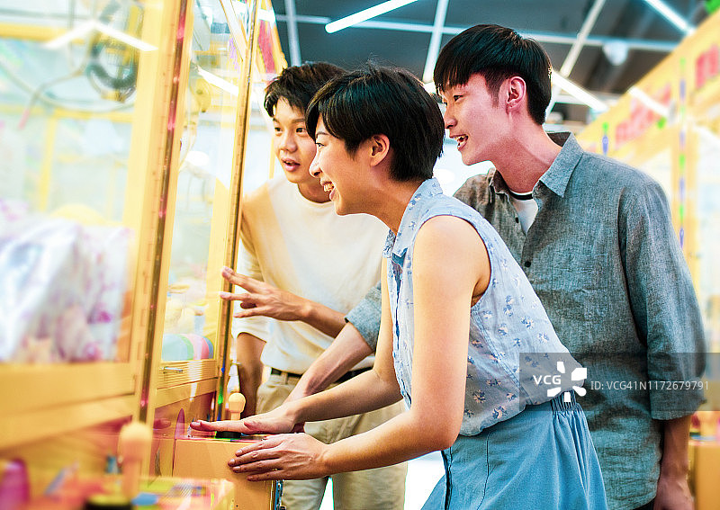 朋友们玩街机抓娃娃机图片素材