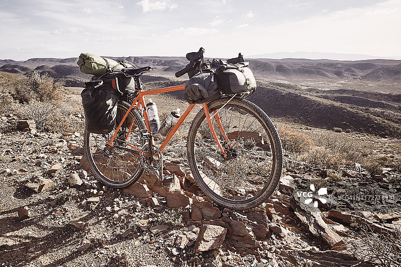 沙漠景观中的橙色探险自行车四分之三正面图图片素材